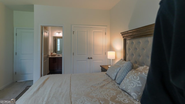 bedroom featuring ensuite bath, carpet flooring, and a closet