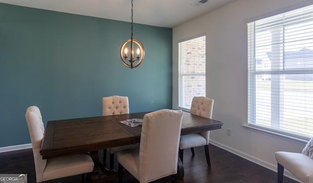 dining area featuring dark wood-type flooring and a chandelier