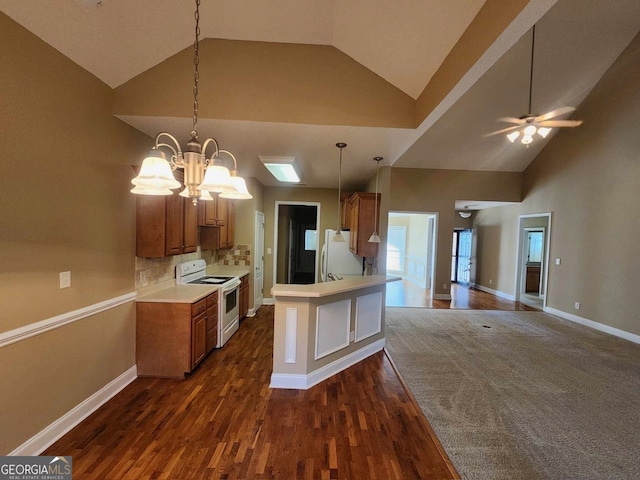 kitchen with white appliances, dark hardwood / wood-style floors, high vaulted ceiling, kitchen peninsula, and ceiling fan with notable chandelier