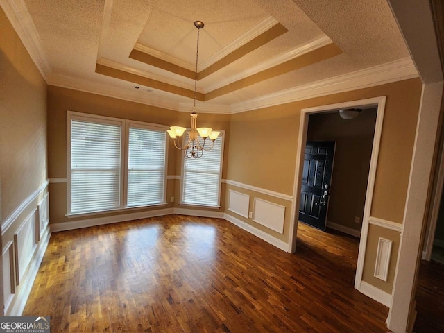 unfurnished dining area with a tray ceiling, a notable chandelier, dark hardwood / wood-style floors, and crown molding