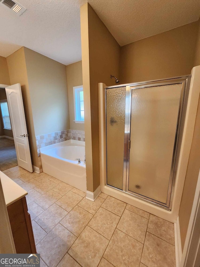 bathroom featuring vanity, a textured ceiling, tile patterned floors, and separate shower and tub