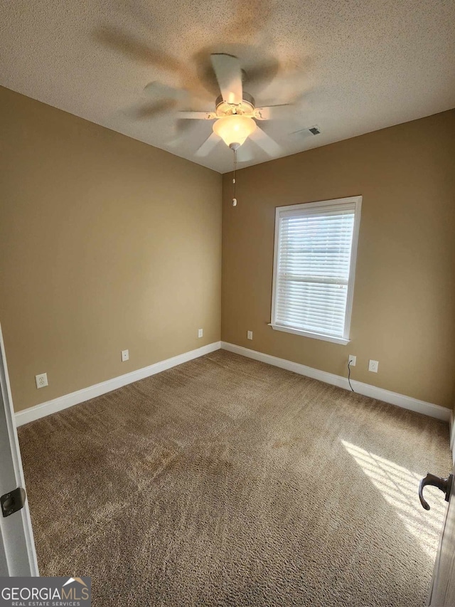 carpeted empty room with ceiling fan and a textured ceiling