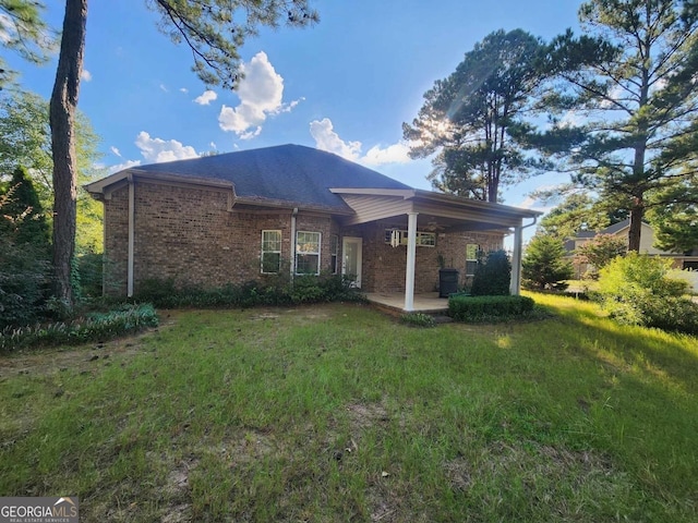 rear view of house featuring a yard and a patio area