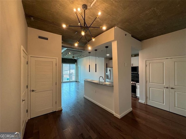 kitchen with a chandelier, sink, hanging light fixtures, appliances with stainless steel finishes, and dark hardwood / wood-style flooring