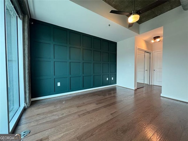 empty room with ceiling fan and hardwood / wood-style flooring