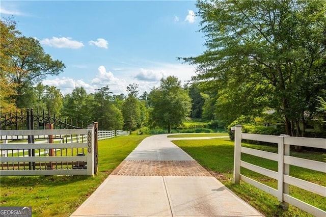 surrounding community featuring a gate, fence, and a yard
