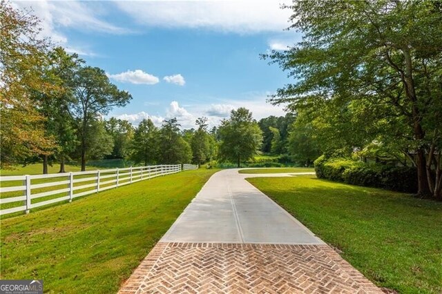 view of property's community featuring fence and a lawn