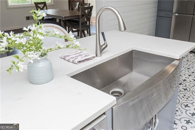 room details featuring stainless steel fridge, wooden walls, and sink