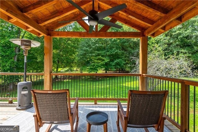 wooden deck with a lawn and a gazebo