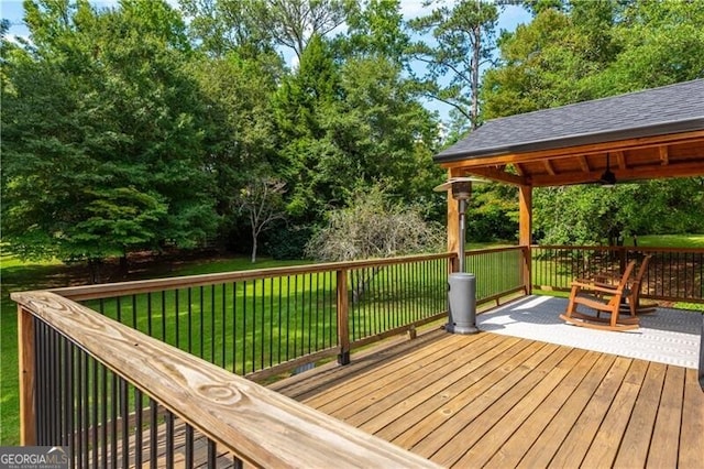 wooden terrace with a lawn and a gazebo