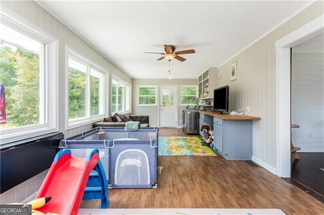 playroom with a ceiling fan, crown molding, and wood finished floors