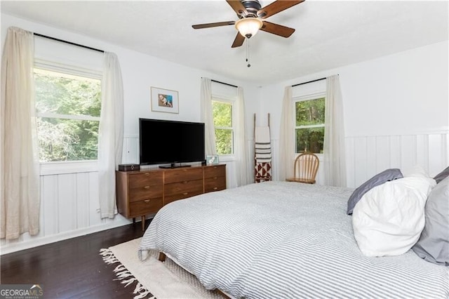 bedroom featuring a wainscoted wall, ceiling fan, and wood finished floors