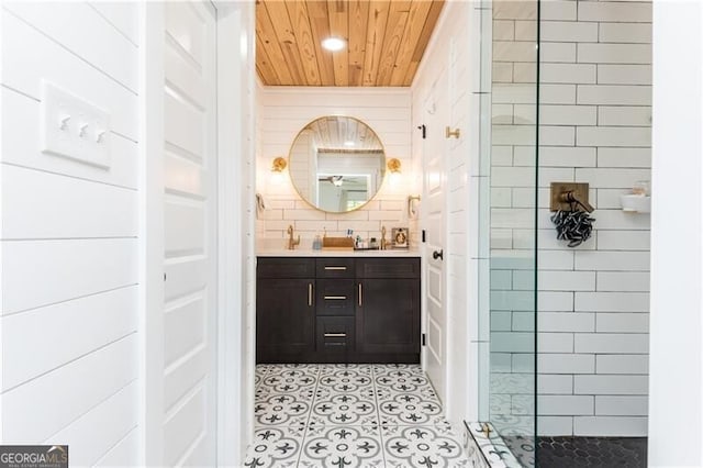 full bath featuring wooden ceiling, tiled shower, vanity, tile patterned flooring, and tile walls