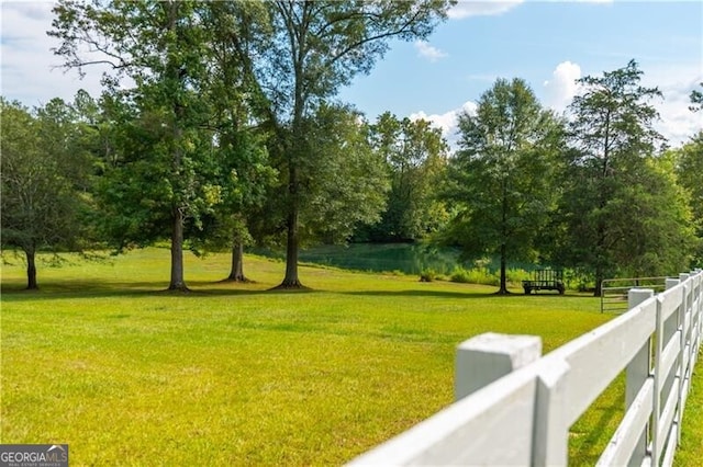 surrounding community featuring fence and a lawn