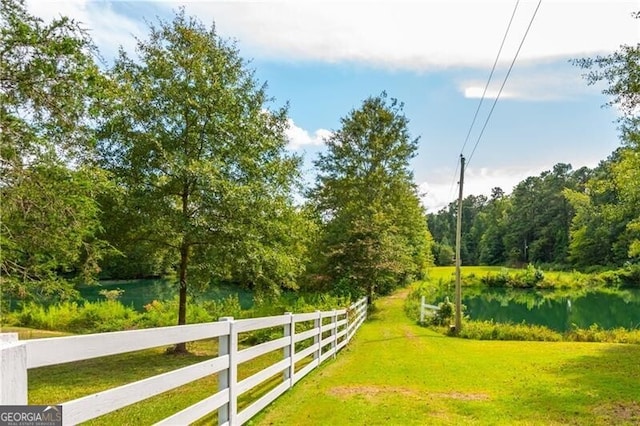 exterior space with a water view, fence, and a yard