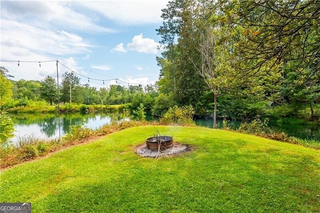 view of yard featuring a water view and a fire pit
