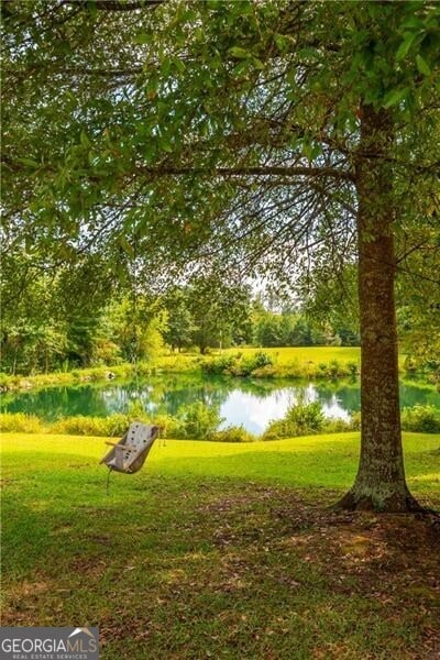 view of home's community with a lawn and a water view
