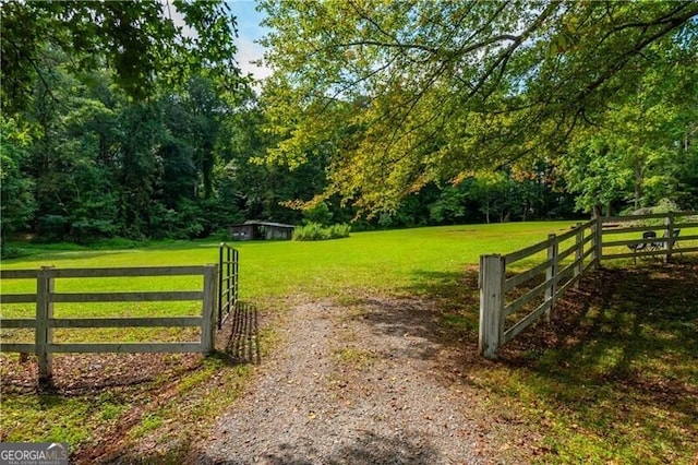 view of gate with a lawn and fence
