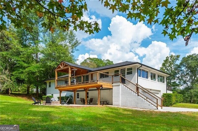 back of house featuring a lawn and a patio area