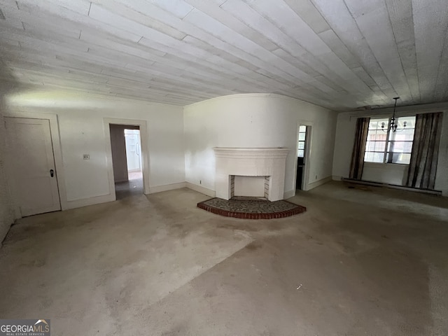 unfurnished living room with concrete flooring, a fireplace, wooden ceiling, and vaulted ceiling