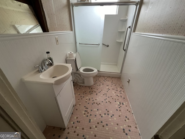 bathroom featuring tile patterned floors, toilet, an enclosed shower, and vanity