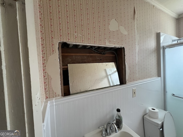 bathroom with ornamental molding, toilet, and sink