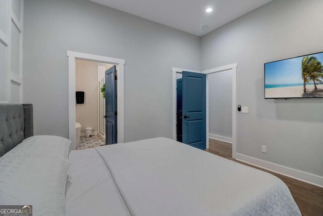 bedroom featuring hardwood / wood-style floors and ensuite bathroom