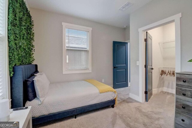 carpeted bedroom featuring a closet and a spacious closet