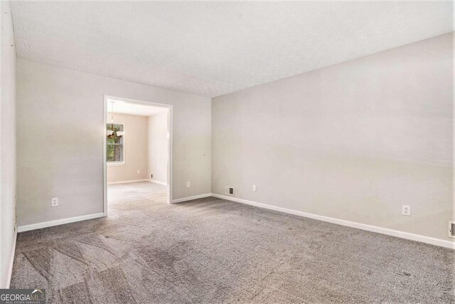 unfurnished room with a textured ceiling and carpet