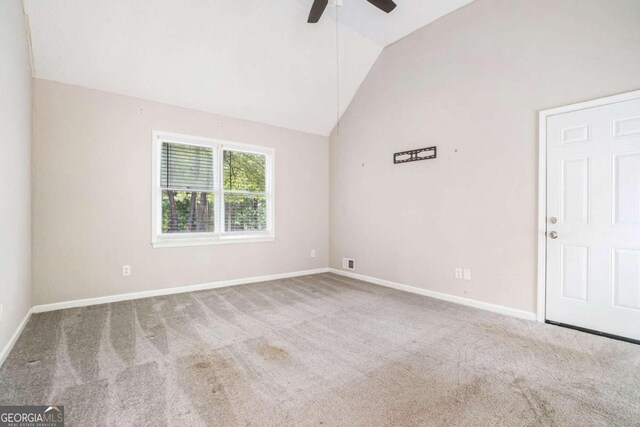 unfurnished room with carpet flooring, ceiling fan, and high vaulted ceiling