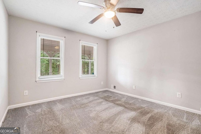 carpeted spare room featuring a textured ceiling and ceiling fan