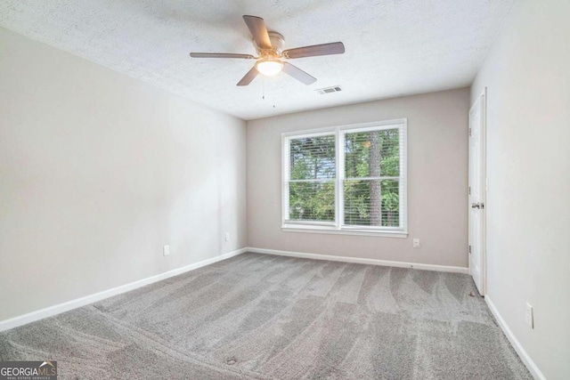 carpeted spare room featuring a textured ceiling and ceiling fan