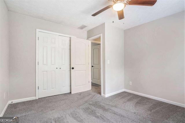 unfurnished bedroom featuring a closet, a textured ceiling, ceiling fan, and carpet floors