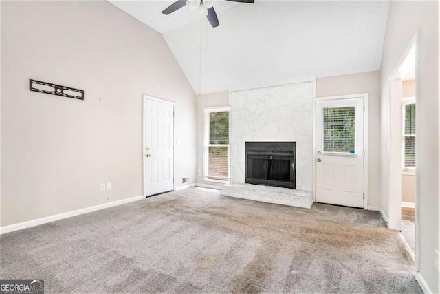 unfurnished living room featuring light colored carpet, ceiling fan, and a fireplace