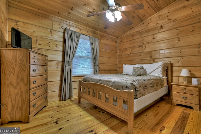 bedroom with wooden walls, vaulted ceiling, light wood-type flooring, wooden ceiling, and ceiling fan