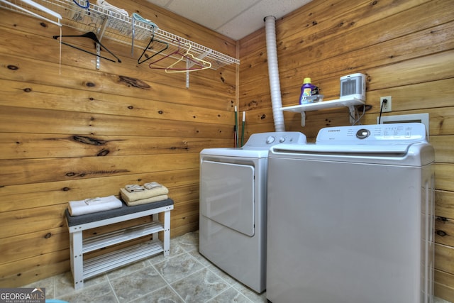 laundry area with washer and clothes dryer and wooden walls