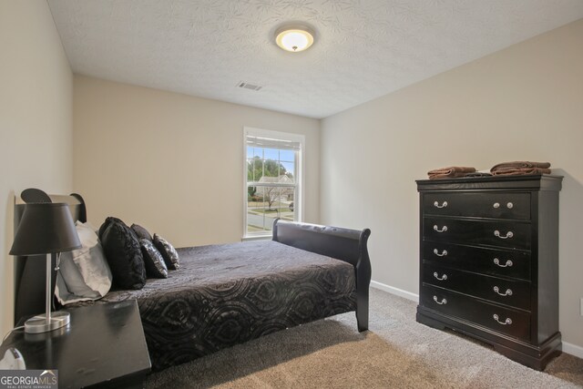 bedroom featuring a textured ceiling and carpet flooring