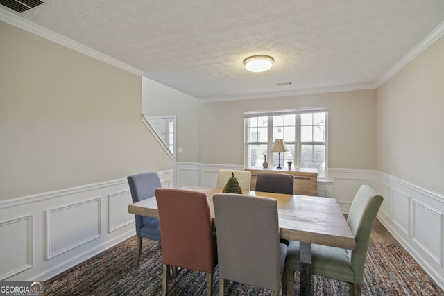 dining space featuring crown molding and a textured ceiling