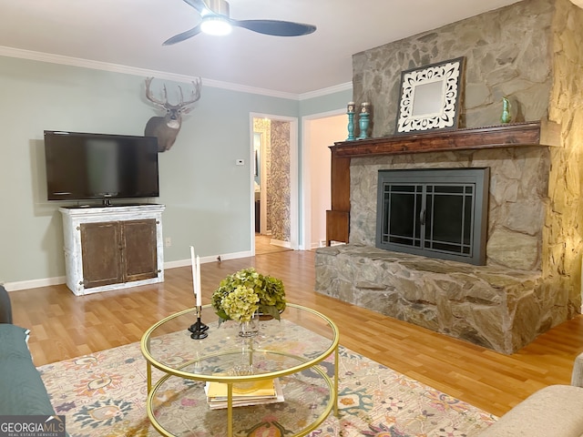 living room featuring ceiling fan, ornamental molding, hardwood / wood-style floors, and a fireplace