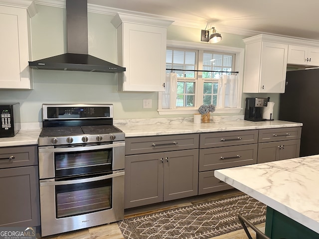 kitchen with gas range, gray cabinetry, wall chimney exhaust hood, and white cabinetry