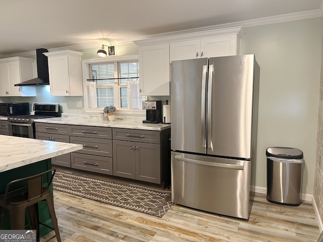 kitchen with light wood-type flooring, white cabinetry, stainless steel appliances, wall chimney exhaust hood, and gray cabinetry