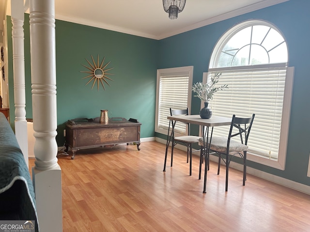 dining area featuring light wood-type flooring and crown molding