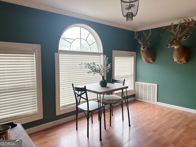 dining room with crown molding and hardwood / wood-style floors