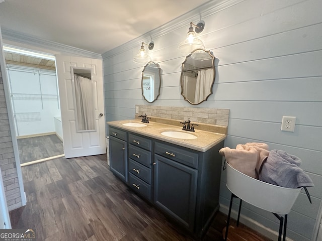 bathroom featuring crown molding, vanity, hardwood / wood-style floors, and wood walls