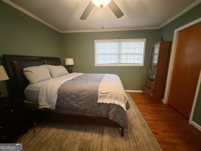 bedroom featuring ceiling fan, ornamental molding, and wood-type flooring