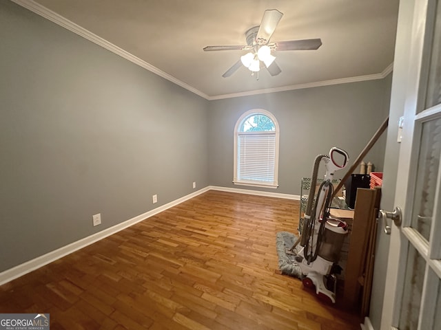 workout area with ornamental molding, hardwood / wood-style flooring, and ceiling fan