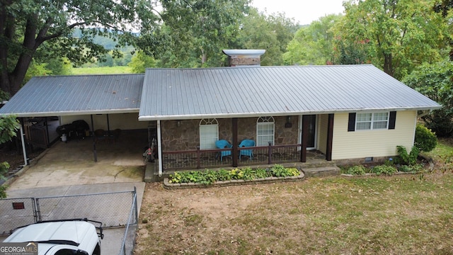 view of front of house featuring a front lawn, covered porch, and a carport