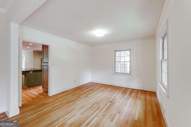 empty room featuring crown molding and light hardwood / wood-style floors