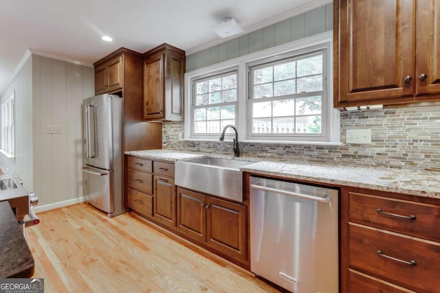 kitchen with light wood-type flooring, a healthy amount of sunlight, stainless steel appliances, and sink