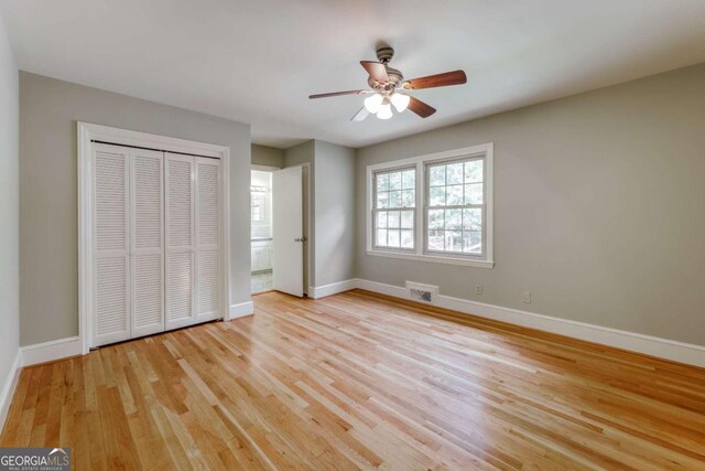 unfurnished bedroom with ceiling fan, a closet, and light hardwood / wood-style floors